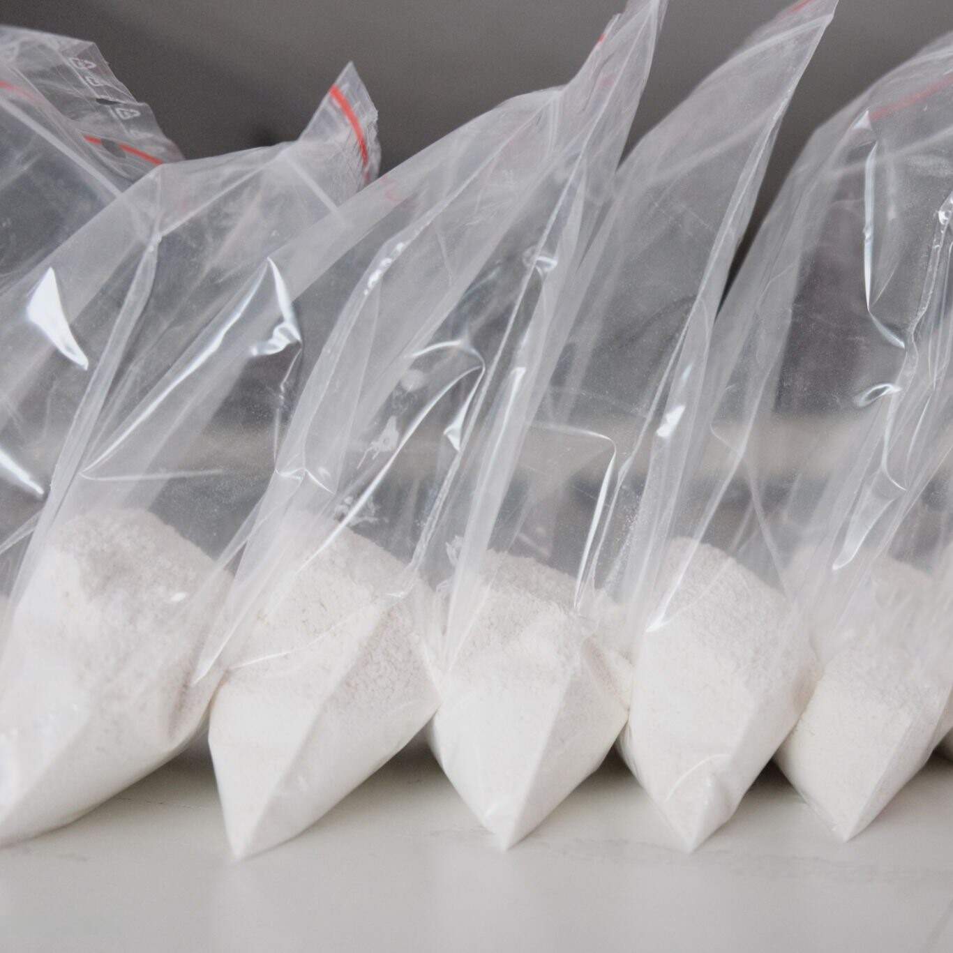Buy fentanyl powder online, sealed in a laboratory sample container, labeled with hazard and controlled substance warnings.